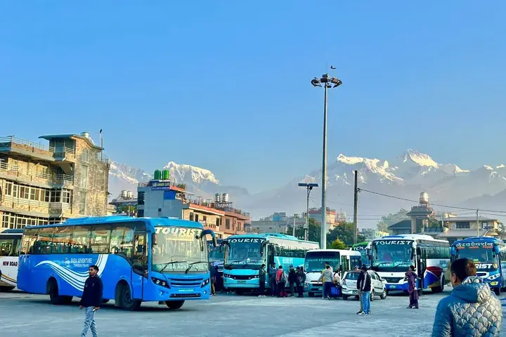 Tourist coaches at Pokhara bus park with the Annapurna range behind