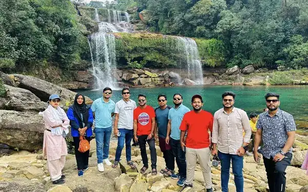 The Trip Express BD team on the rocks beside the turquoise Umngot river pool at Dawki
