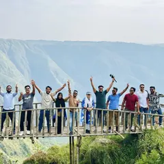 Travellers on a cliff viewpoint above a Meghalaya valley