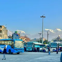 Tourist coaches at Pokhara bus park with the Annapurna range behind